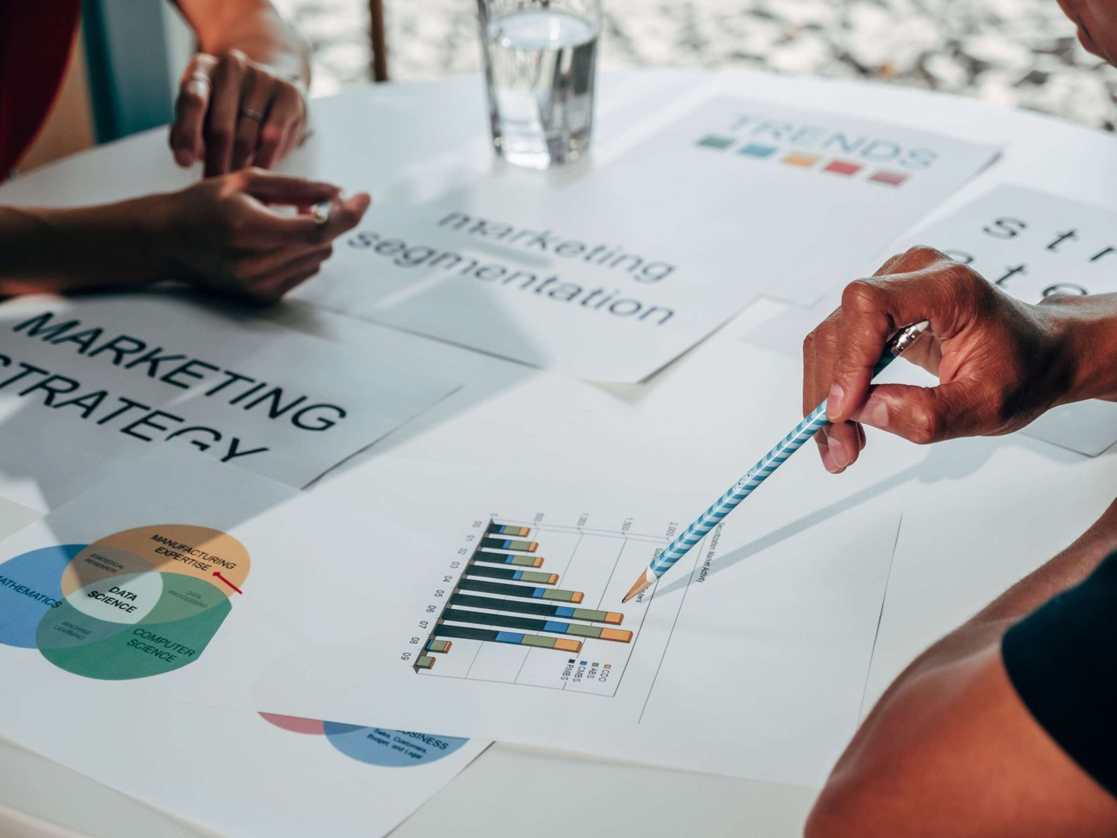 Team working on marketing strategy using data charts and papers in an office meeting.